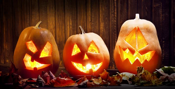 Cara de calabaza de Halloween Jack o linternas sobre fondo de madera —  Fotos de Stock