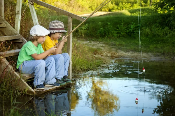 Τα παιδιά με ένα καλάμια ψαρέματος στην ακτή — Φωτογραφία Αρχείου