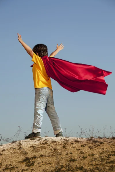 Junge spielt Superhelden am Himmel Hintergrund, Teenager-Superhelden — Stockfoto