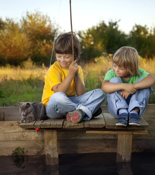 Gelukkige jongens gaan vissen op de rivier, twee kinderen van de fisherma — Stockfoto