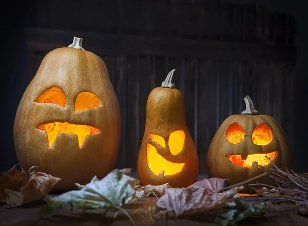 Jack o lanterns Halloween pumpkin face on wooden background — Stock Photo, Image