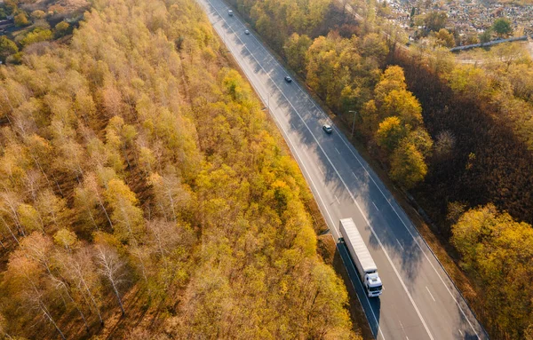 アスファルト高速道路や車やトラックのトラフィックと田舎の高速道路の秋の道路貨物セミトレーラー移動します 空中トップ表示 — ストック写真