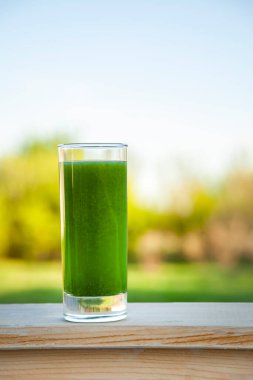 Ahşap zemin üzerinde spirulina olan yeşil smoothie.