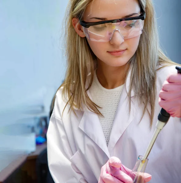beauty scientist girl in chemical laboratory with dropper