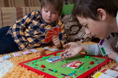 Belgorod, Rusya - APR, 20, 2020: Çocuklar yerde Scrabble oynuyor. Masa oyunu çipleri bulmacada gizlidir. Eğitim, eğlence konsepti Okula geri dönüş