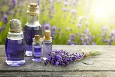 Ahşap masa ve çiçek tarlasında lavanta esansı.