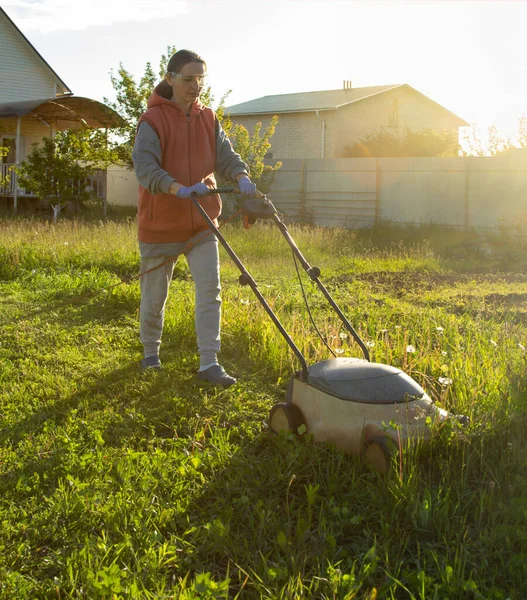 后院里的女人割草割草机 — 图库照片