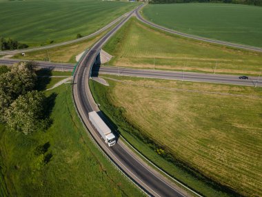 Kargo Semi Trailer 'ın Yön Değiştirdiği Beyaz Kamyonun Havadan Görünümü. Otoyol kavşağı
