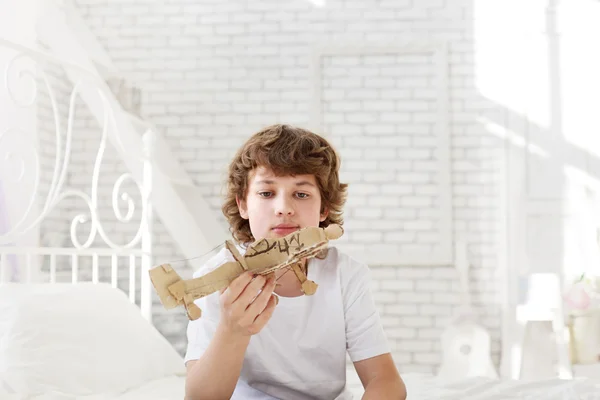 Adolescente con modelo de avión de papel en la habitación —  Fotos de Stock