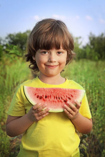 Happy child eating watermelon in the garden — Stock Photo, Image