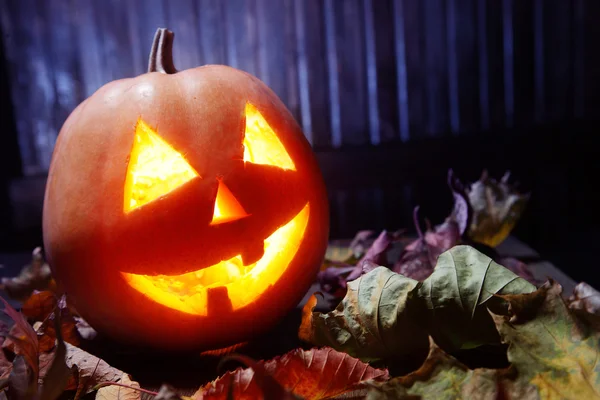 Jack o lanternas Halloween rosto de abóbora no fundo de madeira — Fotografia de Stock