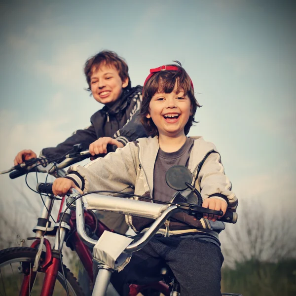 Dos hermanos montar en bicicleta — Foto de Stock