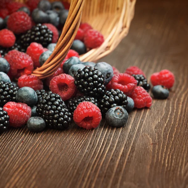 Ahşap bir masa üzerinde bir sepet içinde farklı meyveler — Stok fotoğraf