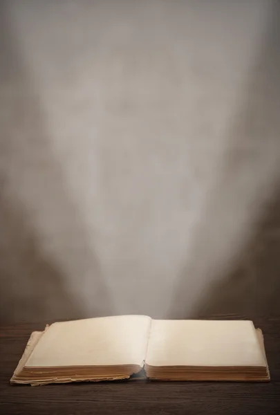 Stare książki otwarte wiązki światła oświetlają strony — Zdjęcie stockowe