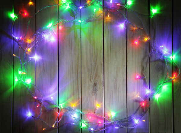 Christmas garlands of lamps on a wooden background.