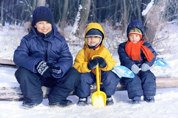 Tre glada pojke spelar i en park på vintern — Stockfoto