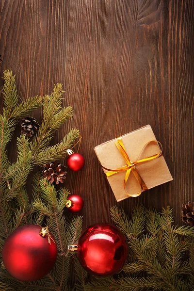 Weihnachtsbaum mit Geschenkschachtel und Dekorationen auf hölzernem Hintergrund — Stockfoto