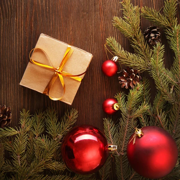 Árbol de Navidad con caja de regalo y decoraciones sobre fondo de madera — Foto de Stock