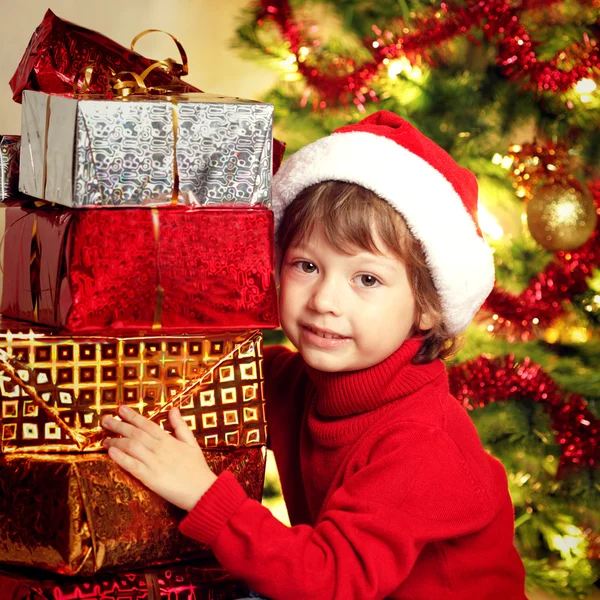 Happy boy with christmas gift near Christmas tree — Stock Photo, Image