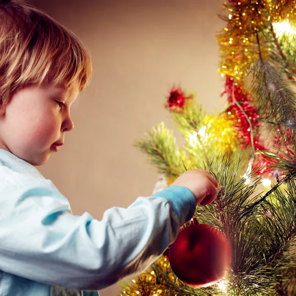 Jongen hangt christmas speelgoed — Stockfoto