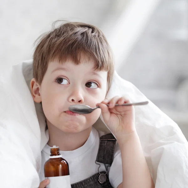 Boy drinking cough syrup — Stock Photo, Image