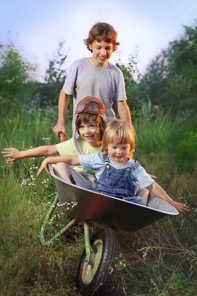 Two friends playing in the plane using a garden carts — Stock Photo, Image