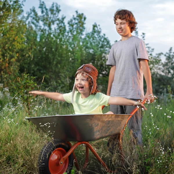Dva přátelé hraje v rovině pomocí Zahradní vozíky — Stock fotografie
