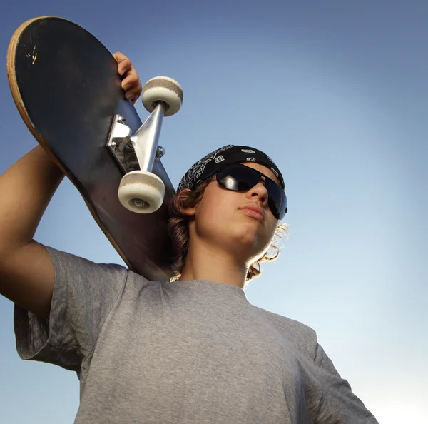 Молодий хлопчик зі скейтбордом в руці — стокове фото