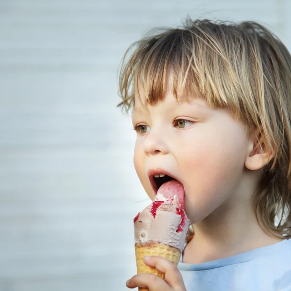 Happy little boy eating an ice cream — Stock Photo, Image