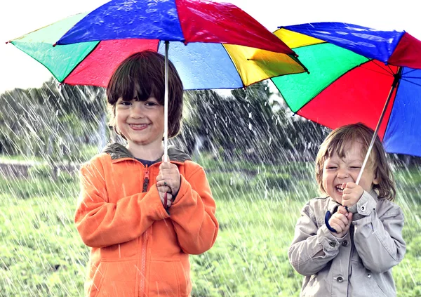 Dos hermanos juegan bajo la lluvia —  Fotos de Stock