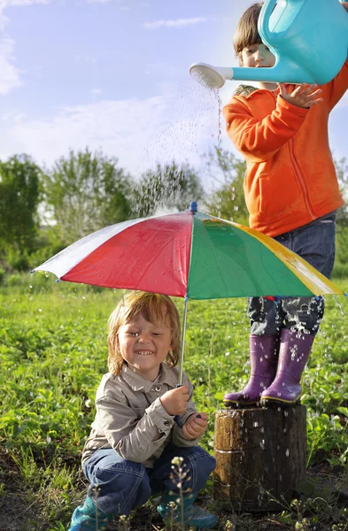 Två bröder spela i regn — Stockfoto