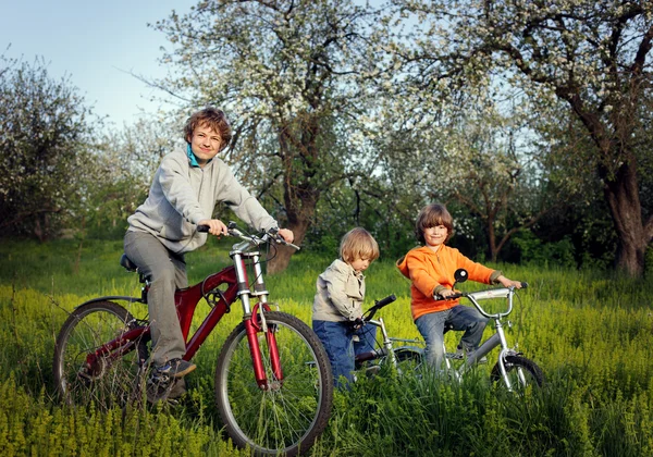 Three brothers ride bikes — Stock Photo, Image