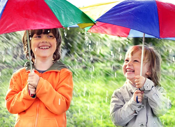 Zwei glückliche Brüder mit Regenschirm im Freien — Stockfoto