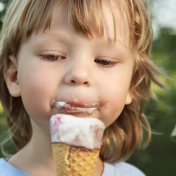 Счастливый маленький мальчик ест мороженое — стоковое фото