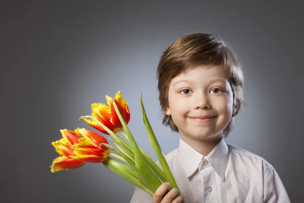 Criança alegre com um buquê de tulipas — Fotografia de Stock