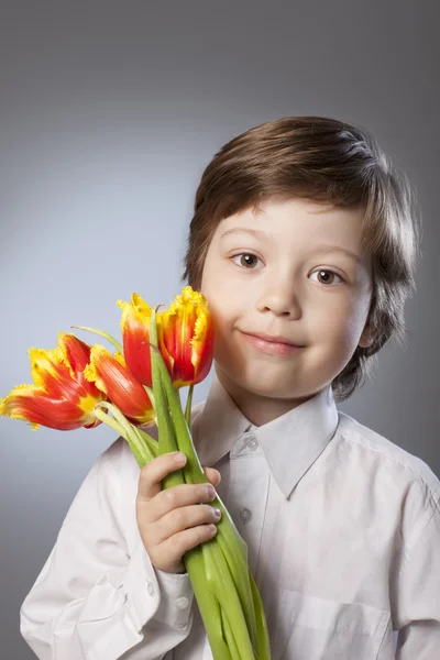 Enfant gai avec un bouquet de tulipes — Photo