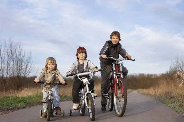 Троє братів їздять на велосипедах — стокове фото