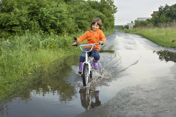 Niño feliz pasando por un charco — Foto de Stock