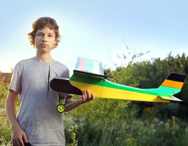 Teen with homemade radio-controlled model aircraft
