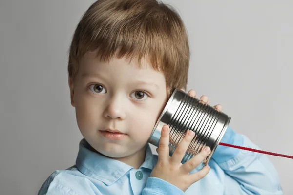 Ragazzo ascolta stagno può telefono — Foto Stock