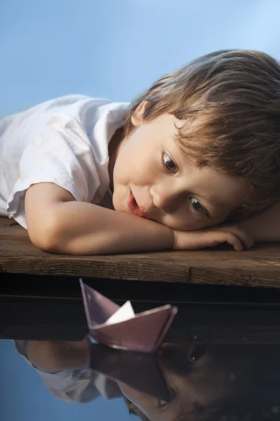 Мальчик играет в бумажный корабль — стоковое фото