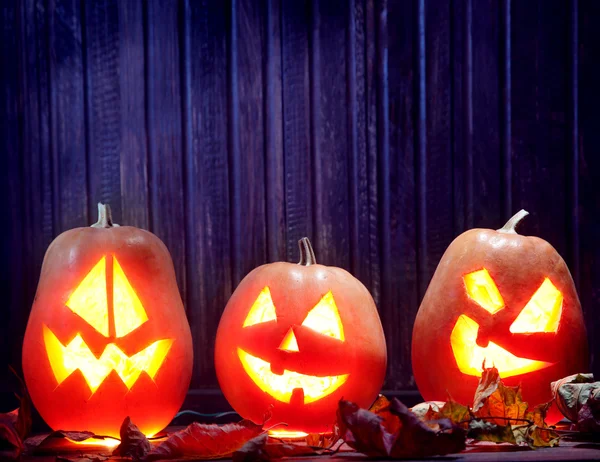 Cara de calabaza de Halloween Jack o linternas sobre fondo de madera — Foto de Stock