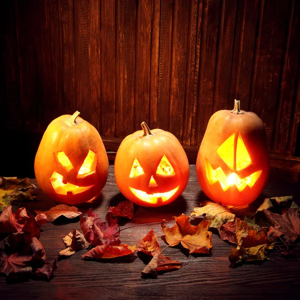 Cara de calabaza de Halloween Jack o linternas sobre fondo de madera —  Fotos de Stock