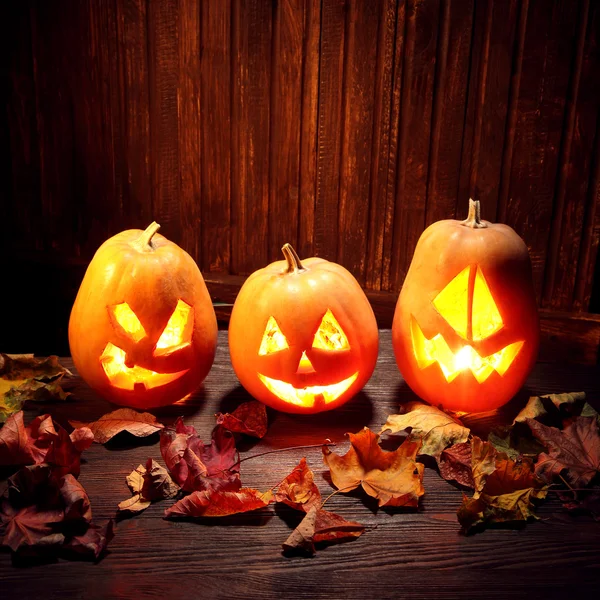 Cara de calabaza de Halloween Jack o linternas sobre fondo de madera — Foto de Stock