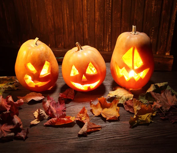 Cara de calabaza de Halloween Jack o linternas sobre fondo de madera — Foto de Stock