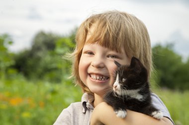 Bir yavru kedi ile mutlu çocuk