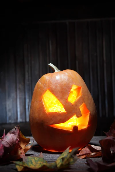 Jack o lanterns Halloween pumpkin face on wooden background — Stock Photo, Image