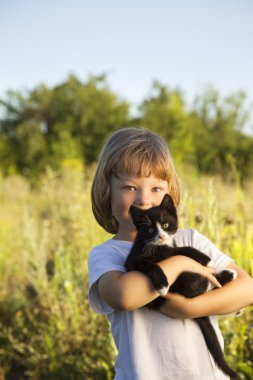 Bir yavru kedi ile mutlu çocuk