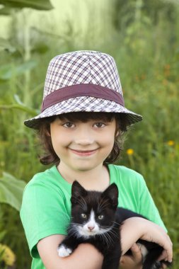 Bir yavru kedi ile mutlu çocuk