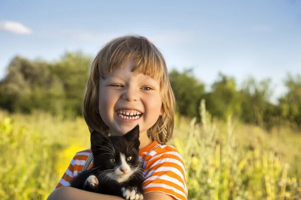 Счастливый ребенок с котенком — стоковое фото